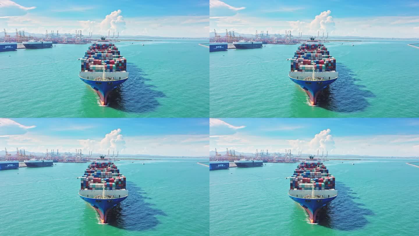 空中前视集装箱货船满载集装箱在海上移动，用于商业物流、进出口、航运或运输。