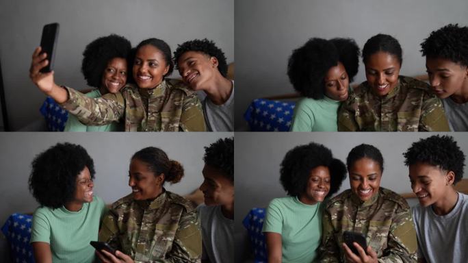 士兵妈妈带着女儿和儿子在家里用手机自拍