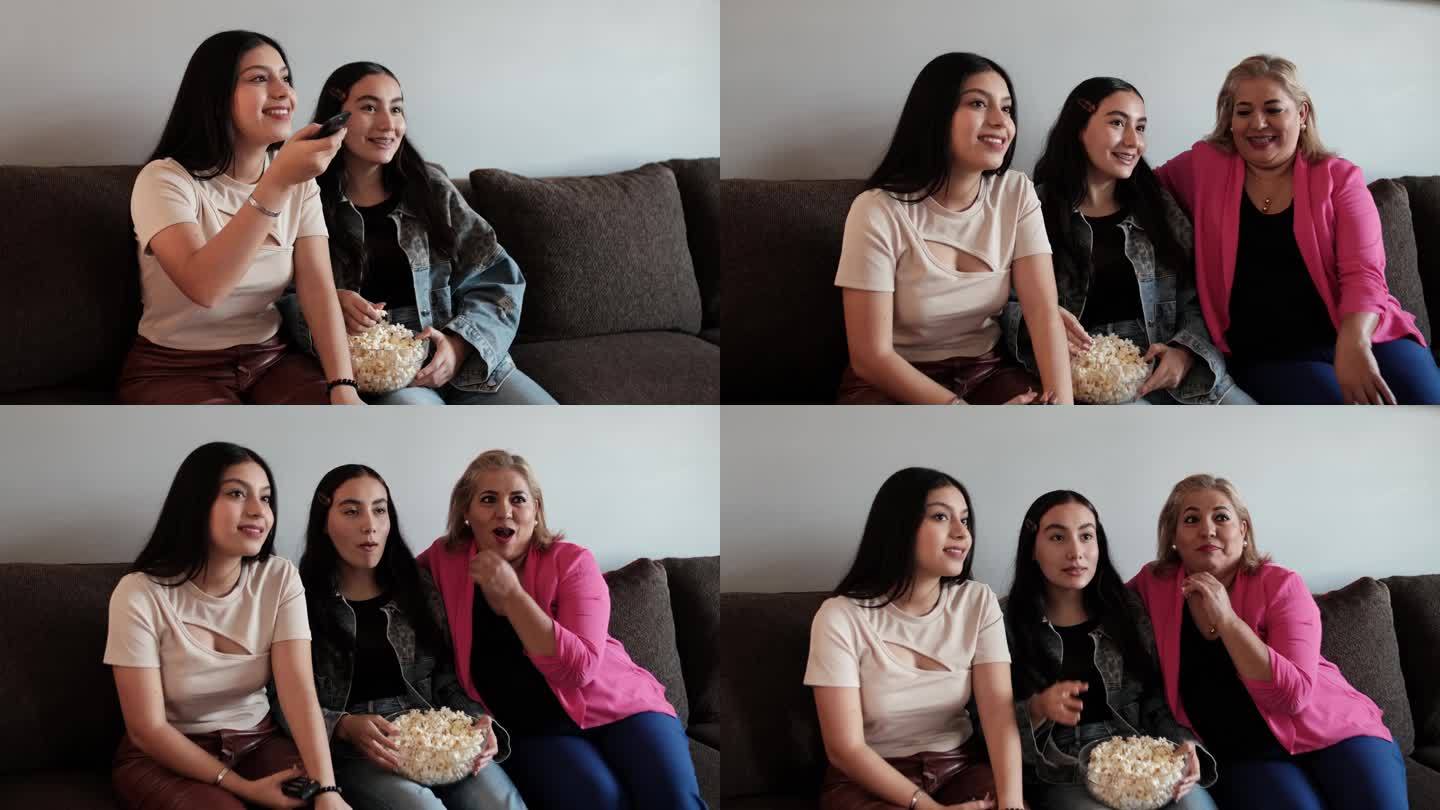 拉丁母亲和女儿在家看电影和吃爆米花