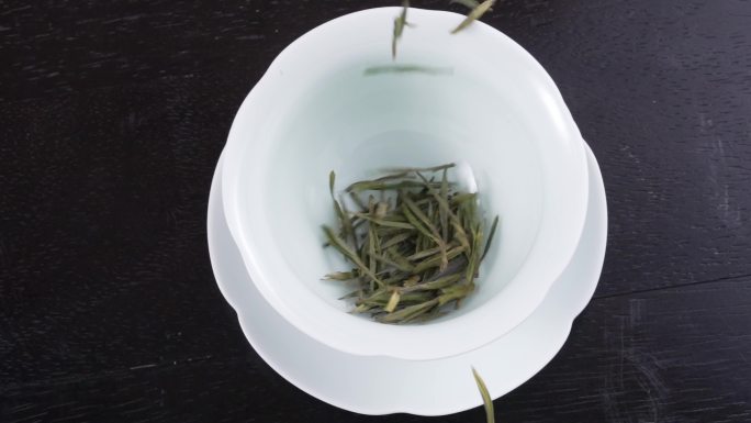 将绿茶叶放入陶瓷茶杯