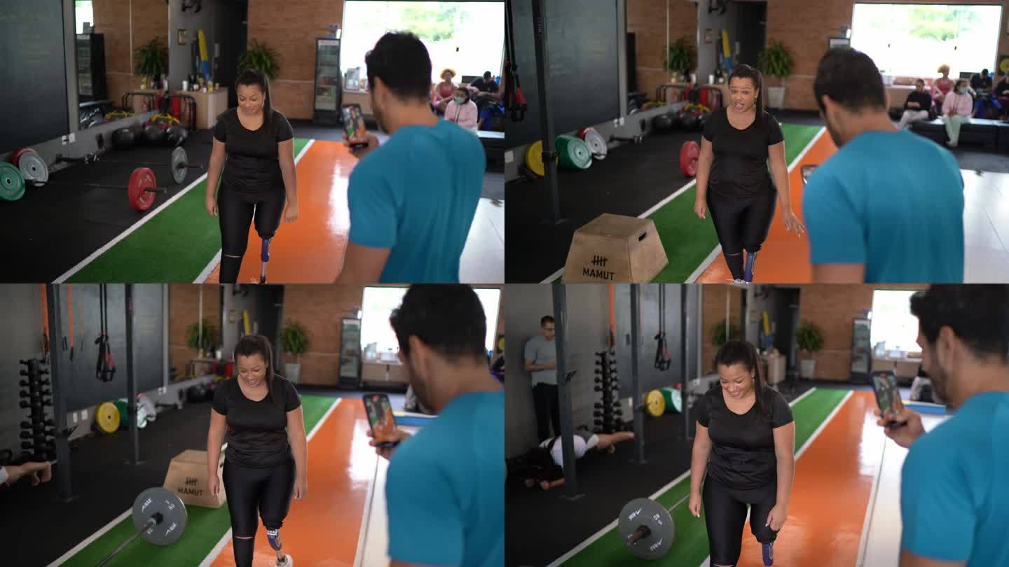私人教练在健身房拍摄并指导女性假肢行走