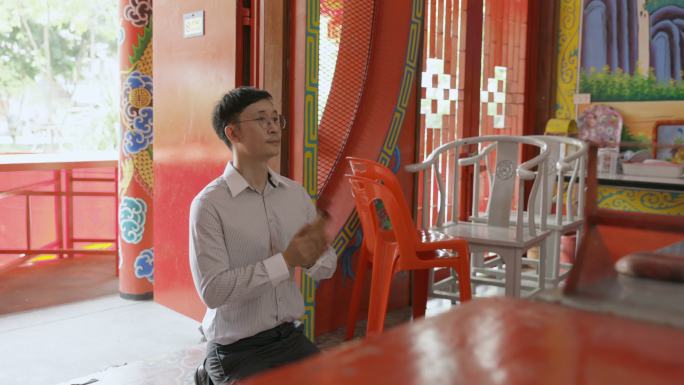 慢动作亚洲男子在中国神社靠运气棍冒险