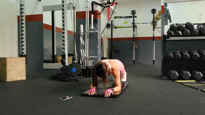 健壮的年轻女运动员在健身房做平板运动