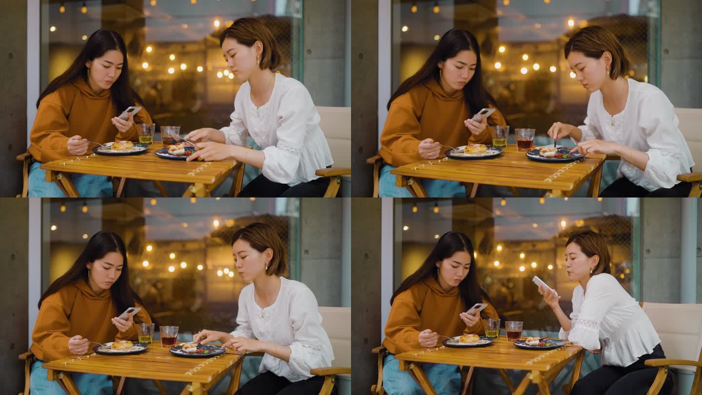 女性朋友在咖啡馆见面，但只使用她们的智能手机。