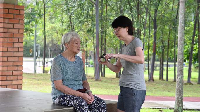 高级亚洲母女在公园休闲散步后休息