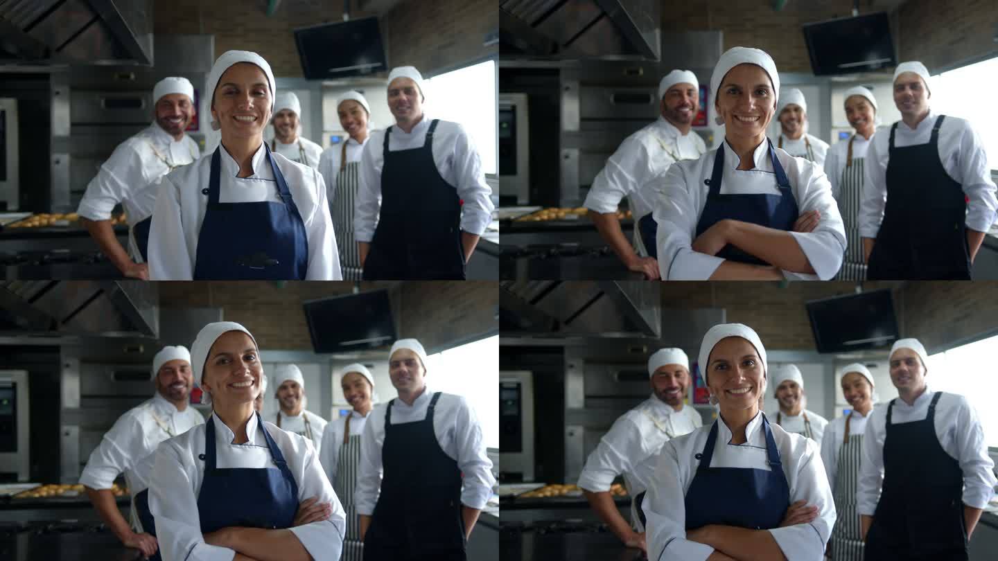 一群快乐的拉丁美洲面包师在一家面包店工作，面带微笑面对镜头，女领导交叉双臂站在前台