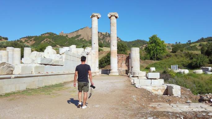 摄影师走在土耳其马尼萨省萨迪斯古城阿耳特弥斯神庙中
