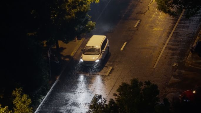 暴雨大风中的城市夜晚，雨中车辆及回家的人