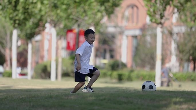 小孩草地踢足球 足球儿童 小学生踢足球