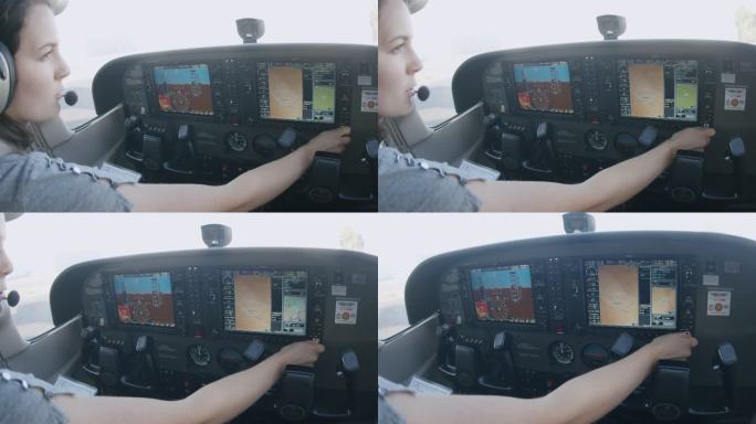 年轻成年女飞行员在多功能飞行控制显示器上加载飞行计划