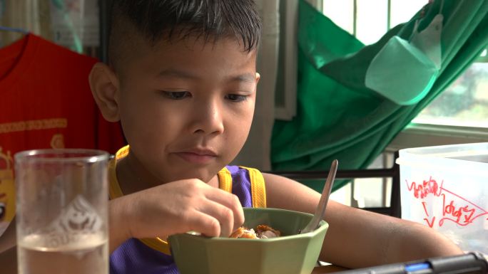 亚洲男孩上学前在家吃健康早餐