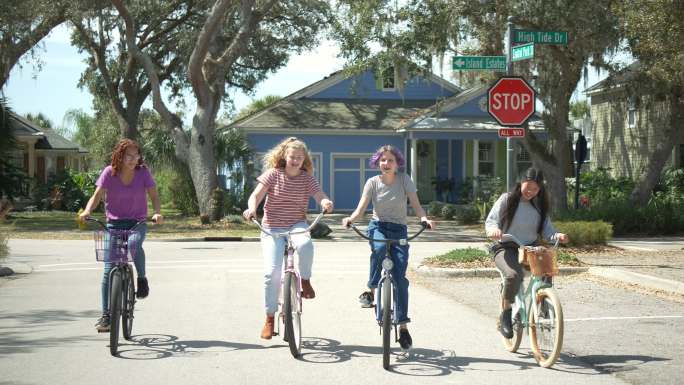 四个多民族少女骑自行车