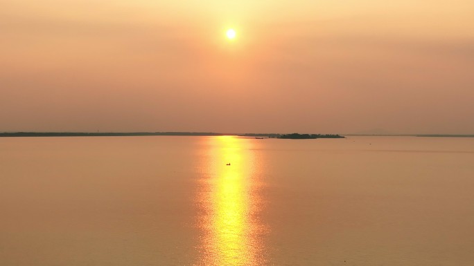 航拍暖色夕阳下湖面上渔船