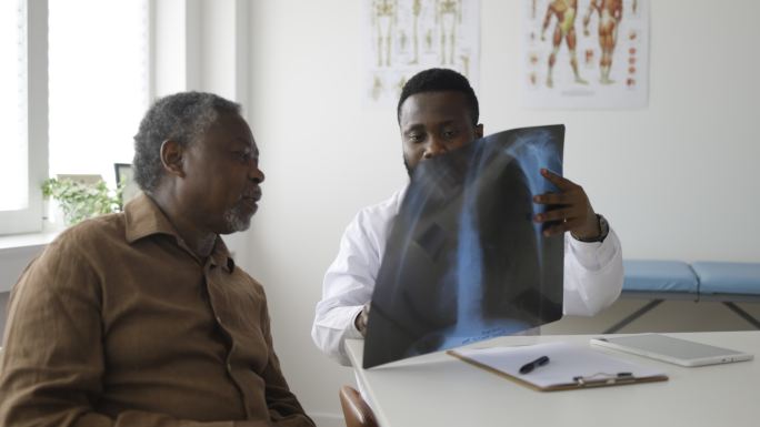 男医生正在分析和澄清患者的X光照片。