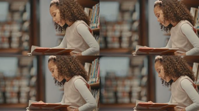 一个小女孩独自在图书馆里。正在做研究的幼儿。可爱的孩子在图书馆做功课。