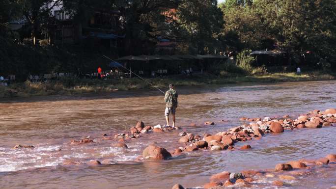 激流的小河溪中的垂钓钓鱼的渔民