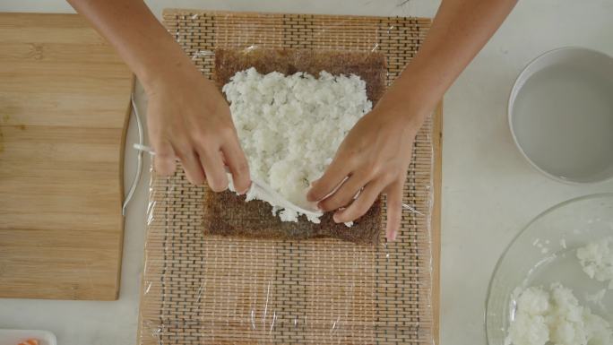 日本女性将大米涂在海藻纸上