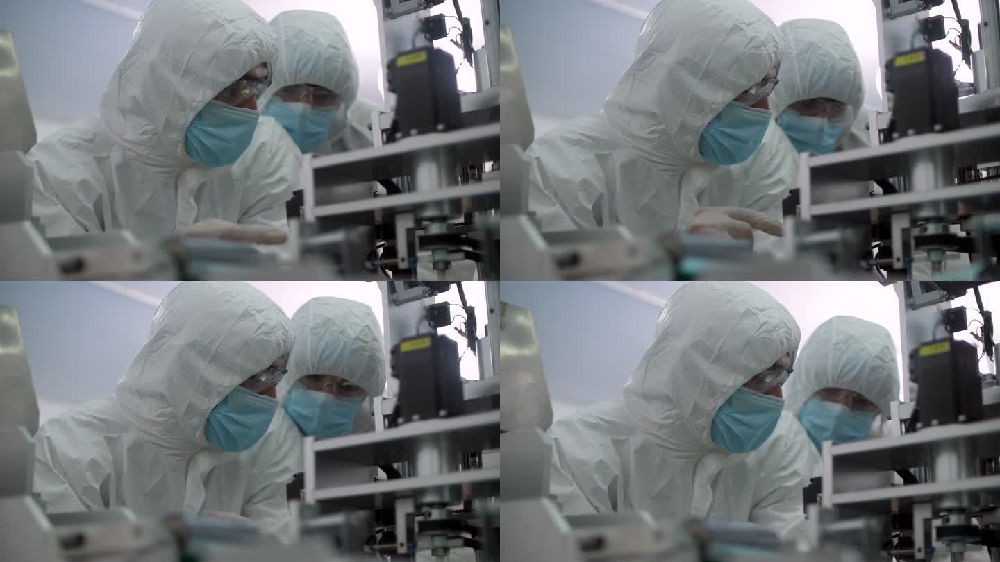 两个研究医用口罩工厂洁净室、工程师和科学家穿着罩衣与数字平板电脑交谈