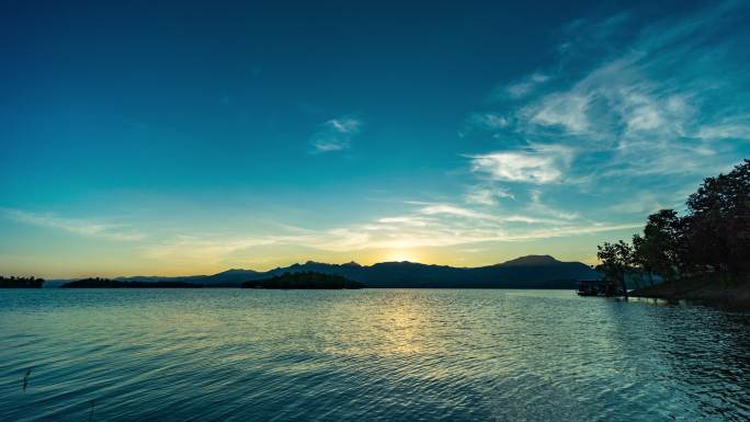 日落时的山和湖的宁静场景，日间黄昏时间流逝视频