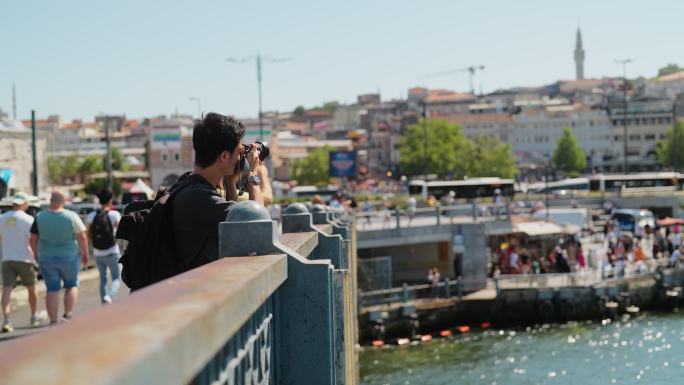 年轻男性摄影师和摄像师旅游者在城市旅行期间拍摄照片和视频