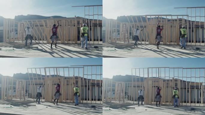 在住宅建筑工地竖起木框墙的木匠建筑工人小组
