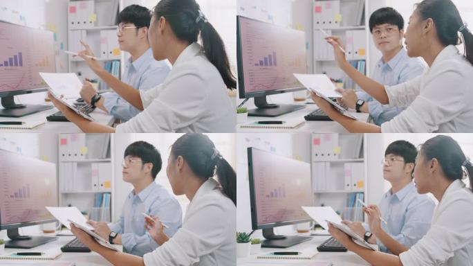 穿着正式衬衫的年轻亚洲商人和女商人坐在电脑显示器前，看着屏幕讨论演示文稿中的图表报告，并在办公室的平