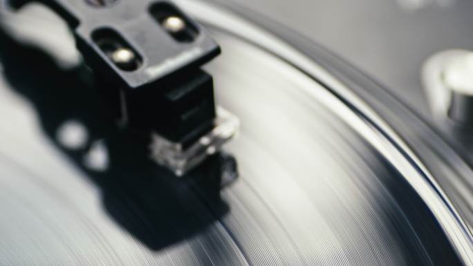 乙烯基唱片旋转，手臂和唱针落在唱片上。