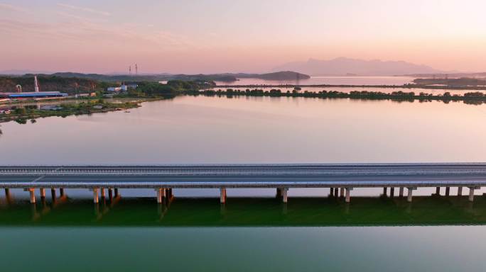 航拍夕阳下穿过鄱阳湖的乡间高速公路