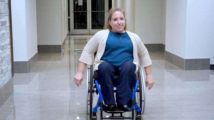 大楼走廊里坐着自动轮椅的女人