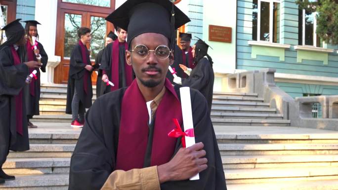一位严肃的男性学者在大学台阶上拿着毕业证书的肖像