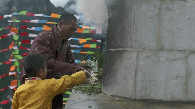 藏族父子在白塔前烧香