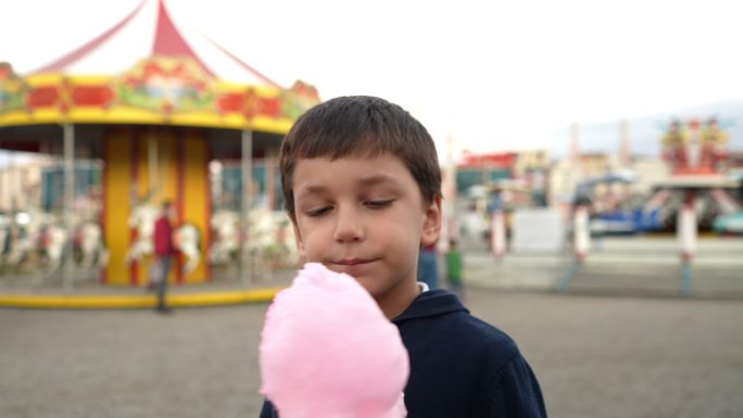 小可爱男孩在游乐场吃棉花糖