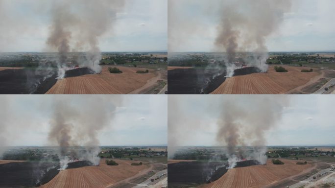 农田起火。鸟瞰图。从直升机上看，从远处看。相机向后起飞。棕灰色烟雾。可见红色火焰和大量消防车。