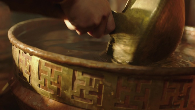 从铜水缸舀水到铜壶中