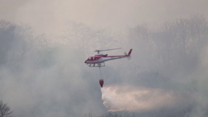 SLO MO直升机，消防队员在野火森林中喷水灭火