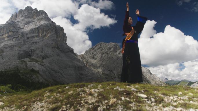 航拍藏族女子山上祈祷