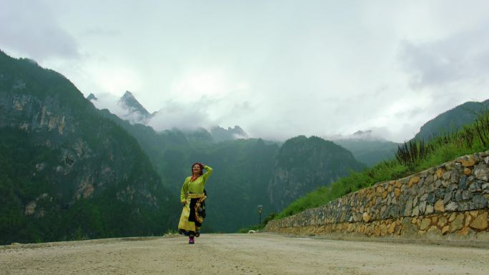 藏族女子在山间土路上奔跑