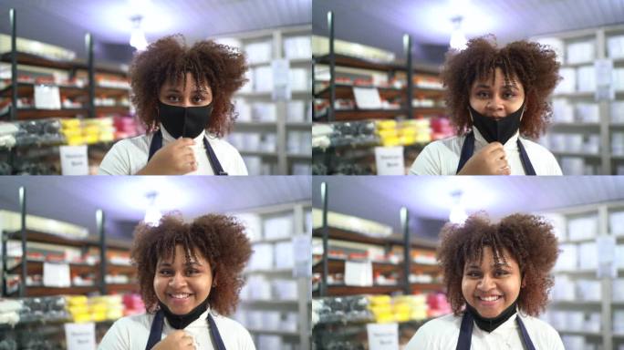 一名年轻女子在她的小商店摘下口罩的肖像