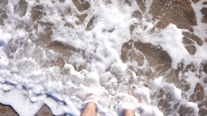 沙滩上的慢动作脚和波浪