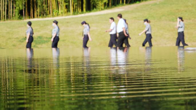 一排女警察和视察领导从湖边山坡上列队走过