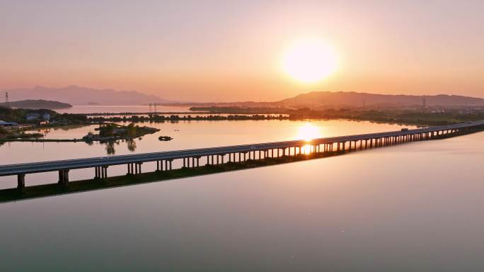 航拍夕阳下穿过鄱阳湖的乡间高速公路