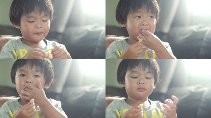 小男孩在家里用手吃东西