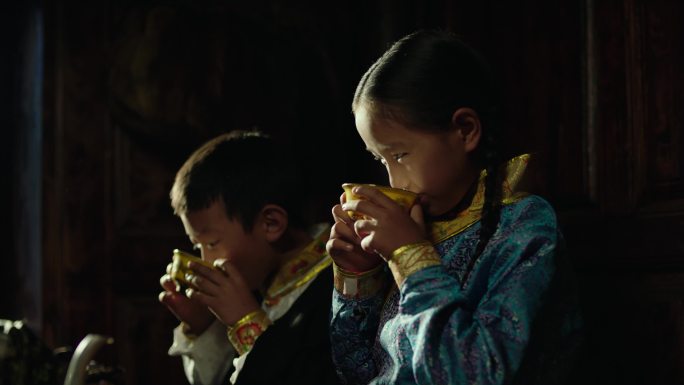 藏族男孩女孩喝酥油茶