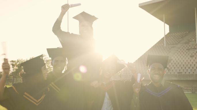 快乐的学生在大学毕业典礼上欢呼。激动的毕业生拿着文凭庆祝学业成就的照片。多元化的朋友群为未来而兴奋