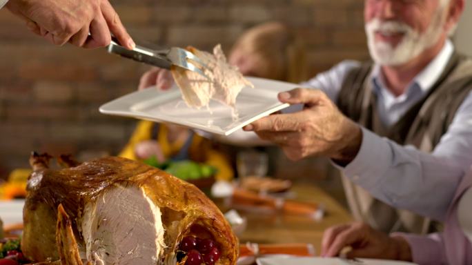 感恩节晚餐期间切白肉的人。