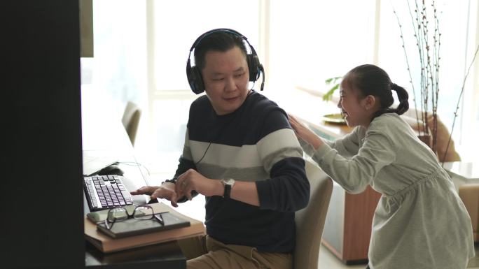 不幸的亚裔中国女儿玩得心烦意乱，打扰了在家工作的父亲，父亲与同事一起用耳机视频通话