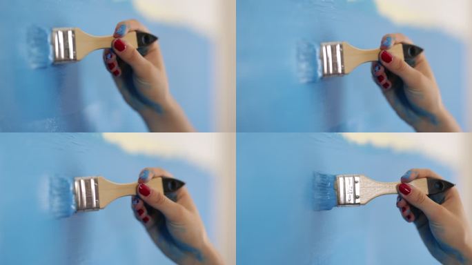 少女用蓝色颜料粉刷墙壁