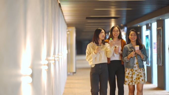 周末，快乐的亚裔中国女性朋友走在走廊上看电影