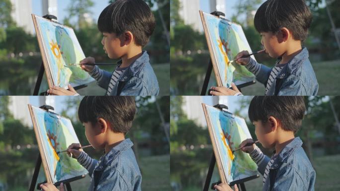 男孩在村庄、公园用水彩和画笔画画。