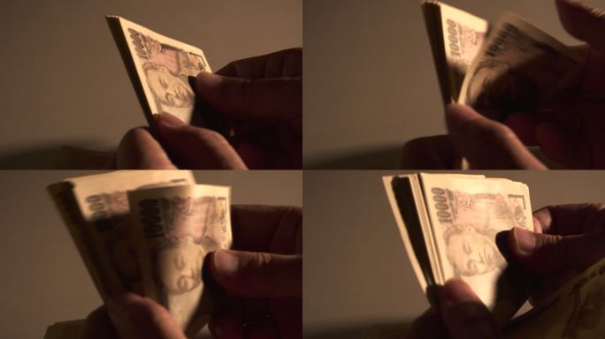 男人们手里拿着现金。数日元钞票的人。